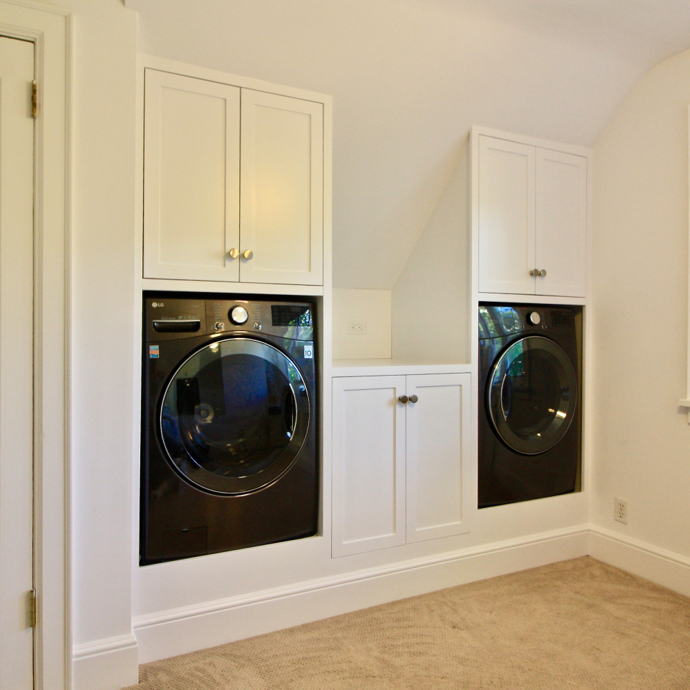 Foto på en funkis tvättstuga, med skåp i shakerstil, vita skåp, träbänkskiva och en tvättmaskin och torktumlare bredvid varandra
