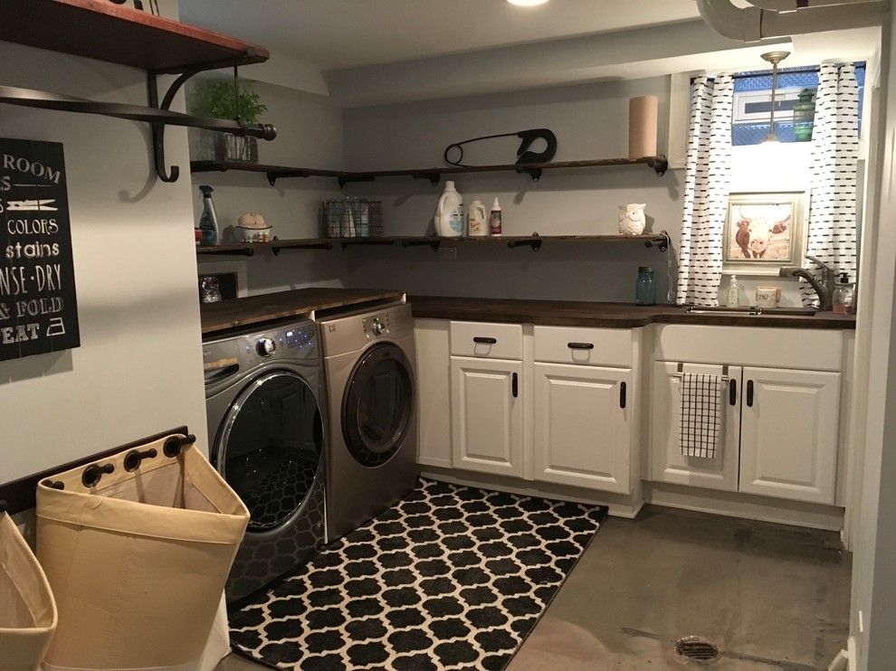 Idéer för att renovera en mellanstor lantlig tvättstuga enbart för tvätt, med en undermonterad diskho, träbänkskiva, grå väggar, betonggolv, en tvättmaskin och torktumlare bredvid varandra och grått golv