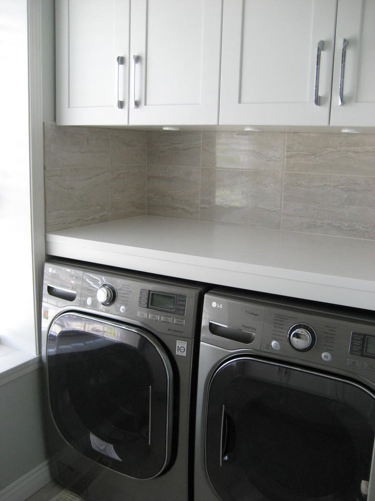 Exempel på en mellanstor modern tvättstuga, med en undermonterad diskho, skåp i shakerstil, vita skåp, bänkskiva i koppar, en tvättmaskin och torktumlare bredvid varandra och grå väggar