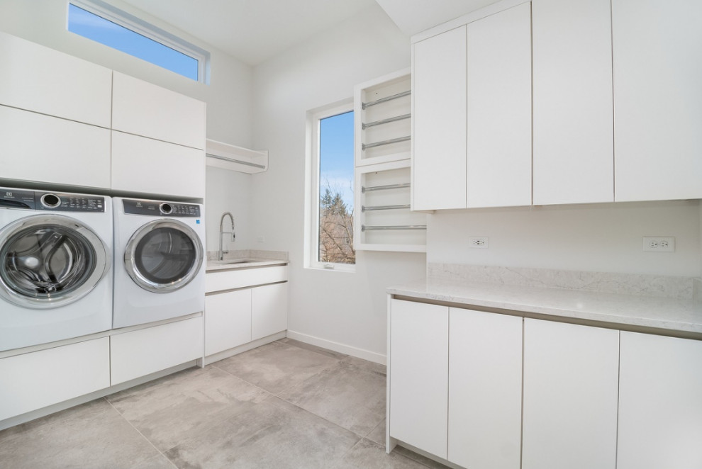 Large contemporary separated utility room in Chicago with a submerged sink, flat-panel cabinets, white cabinets, white walls, a side by side washer and dryer, multi-coloured floors, white worktops and porcelain flooring.