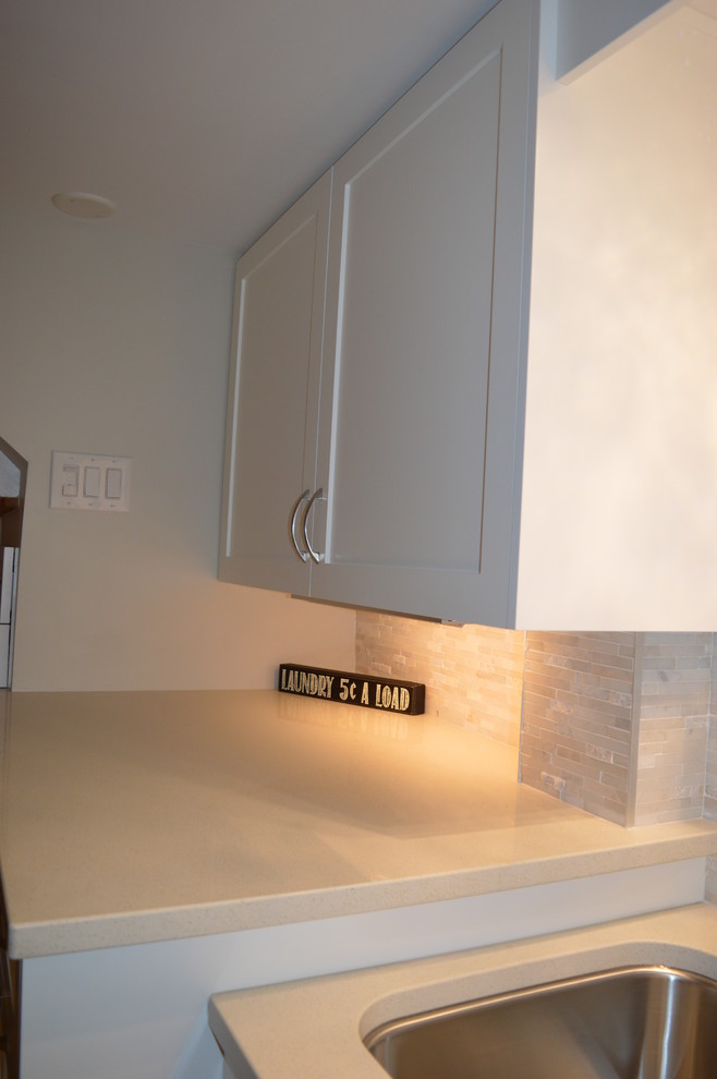Photo of a medium sized traditional single-wall utility room in Toronto with an utility sink, shaker cabinets, white cabinets, quartz worktops, grey walls, ceramic flooring and a side by side washer and dryer.