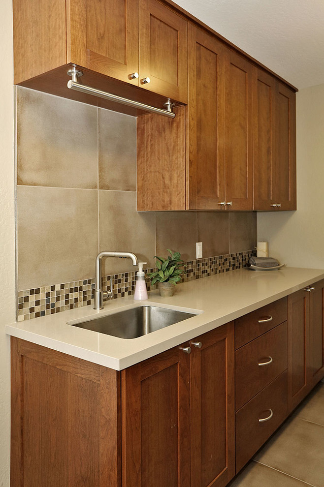 Medium sized classic galley separated utility room in San Francisco with a submerged sink, shaker cabinets, dark wood cabinets, composite countertops, ceramic flooring, beige walls, a side by side washer and dryer and beige floors.