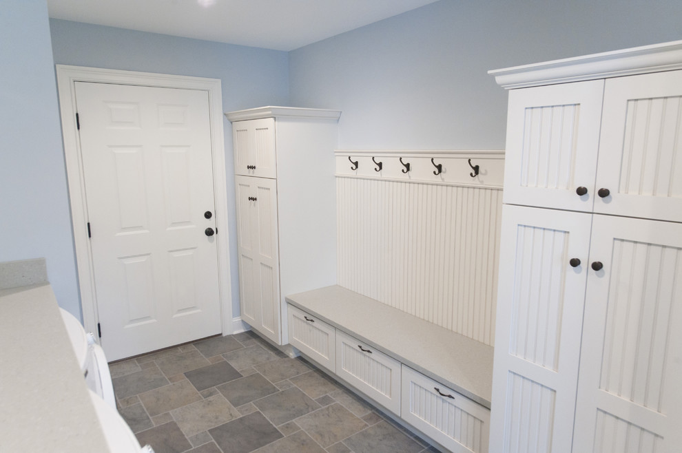 Inspiration for a timeless ceramic tile and multicolored floor laundry room remodel in Philadelphia with white cabinets, blue walls, a side-by-side washer/dryer and recessed-panel cabinets