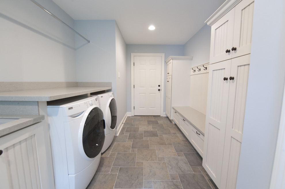 Inspiration för en vintage tvättstuga, med vita skåp, blå väggar, klinkergolv i keramik, en tvättmaskin och torktumlare bredvid varandra och flerfärgat golv