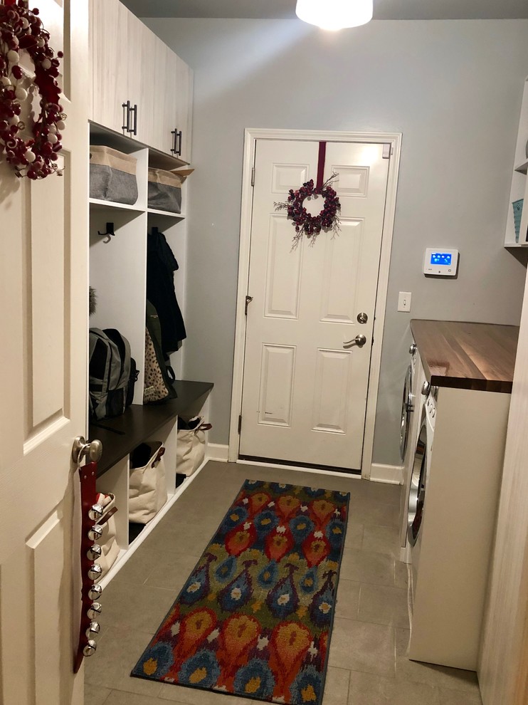 Example of a mid-sized transitional galley gray floor utility room design in Chicago with flat-panel cabinets, light wood cabinets, gray walls, a side-by-side washer/dryer and brown countertops