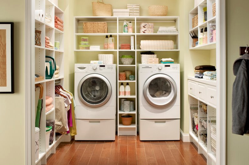 トロントにある中くらいなトランジショナルスタイルのおしゃれな洗濯室 (コの字型、白いキャビネット、ベージュの壁、無垢フローリング、左右配置の洗濯機・乾燥機、茶色い床、オープンシェルフ) の写真