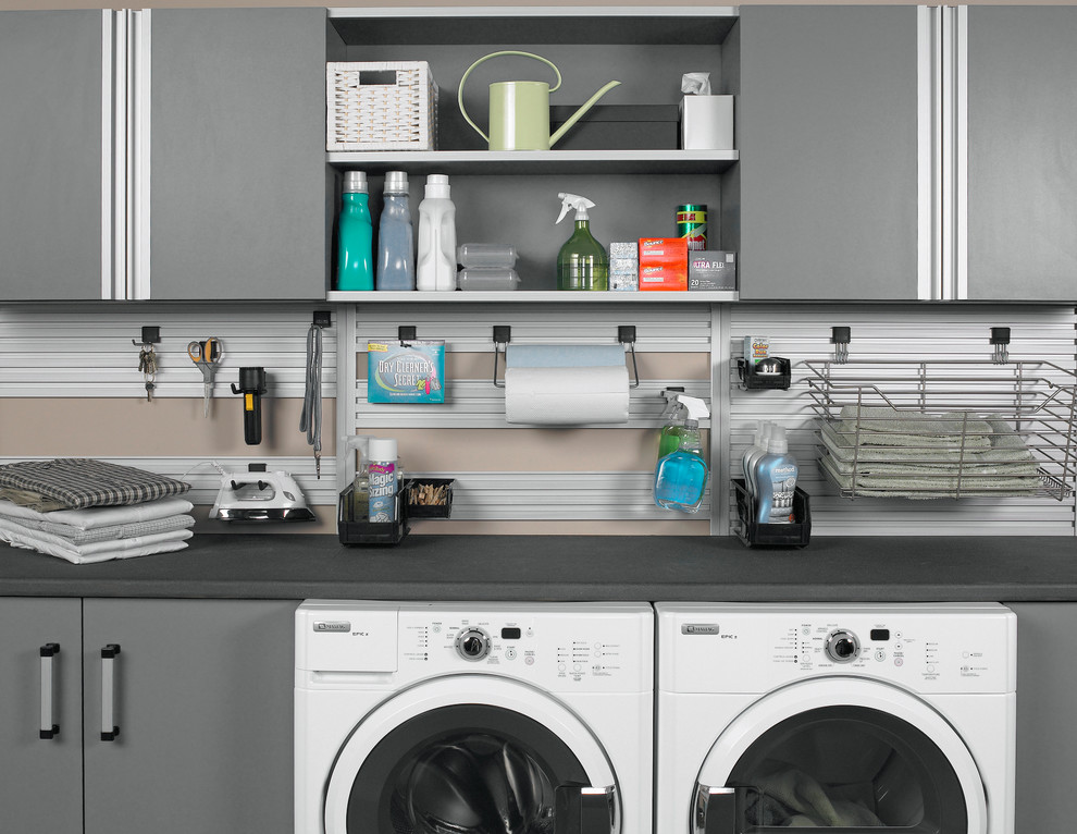 Modelo de lavadero minimalista con armarios con paneles lisos, puertas de armario grises y lavadora y secadora juntas