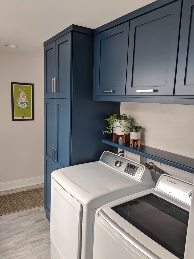 Foto di una piccola lavanderia chic con ante in stile shaker, ante blu, pareti grigie, pavimento con piastrelle in ceramica, lavatrice e asciugatrice affiancate e pavimento grigio