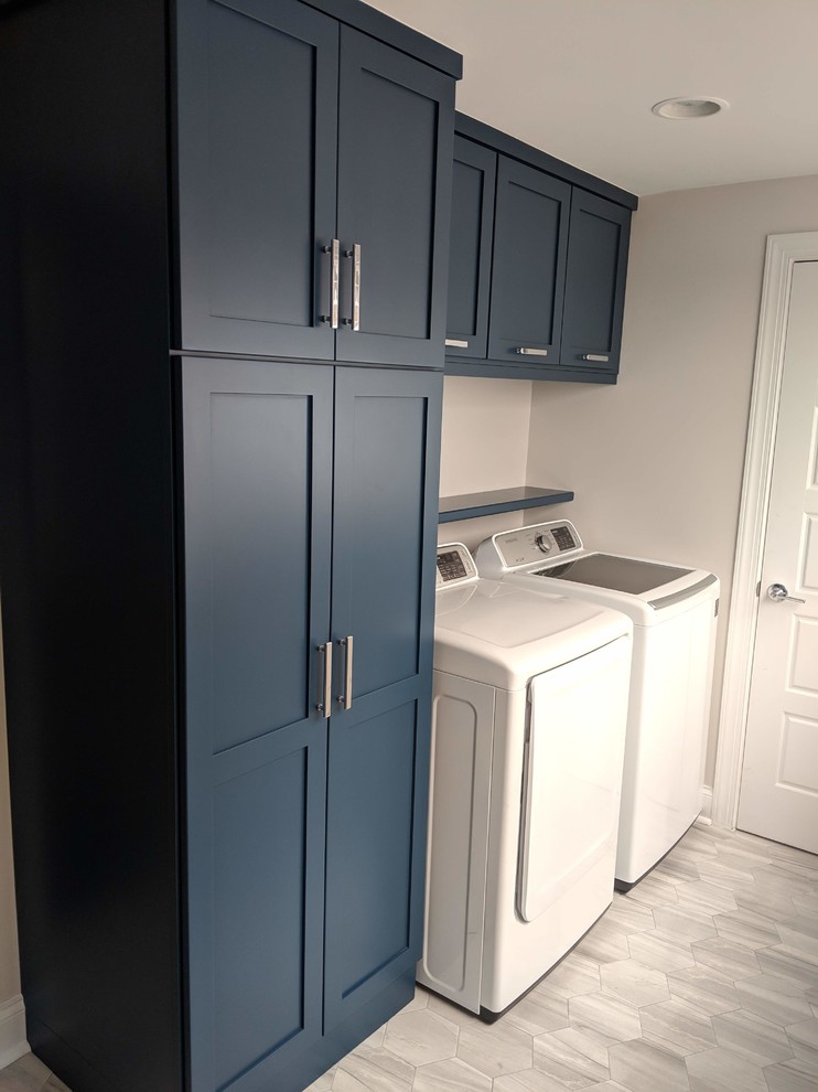 Idee per una piccola lavanderia classica con ante in stile shaker, ante blu, pareti grigie, pavimento con piastrelle in ceramica, lavatrice e asciugatrice affiancate e pavimento grigio