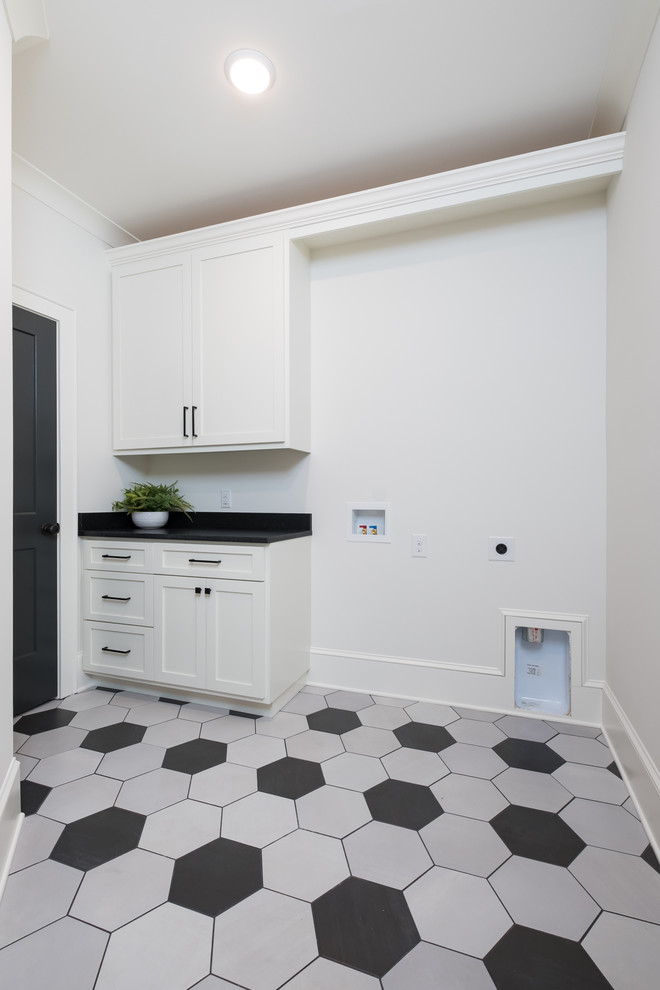 Large country single-wall separated utility room in Charlotte with granite worktops, beige walls, a side by side washer and dryer and black worktops.