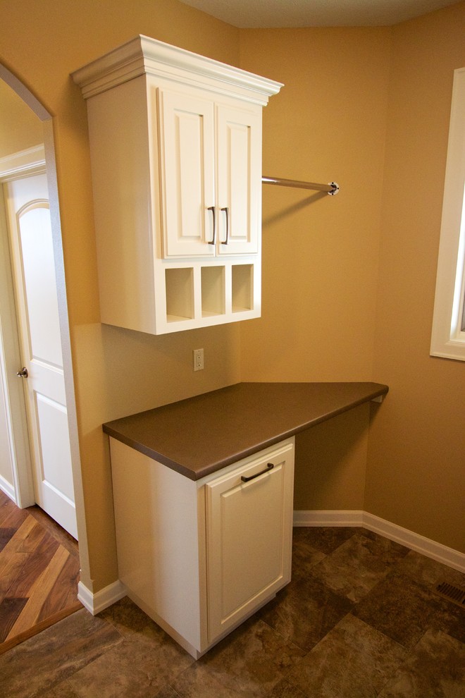 Photo of a medium sized utility room in Other with raised-panel cabinets, white cabinets, laminate countertops and a side by side washer and dryer.
