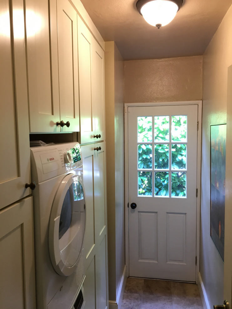 Foto di una piccola lavanderia multiuso country con ante in stile shaker, ante bianche, pareti beige, pavimento in linoleum, lavatrice e asciugatrice a colonna e pavimento beige