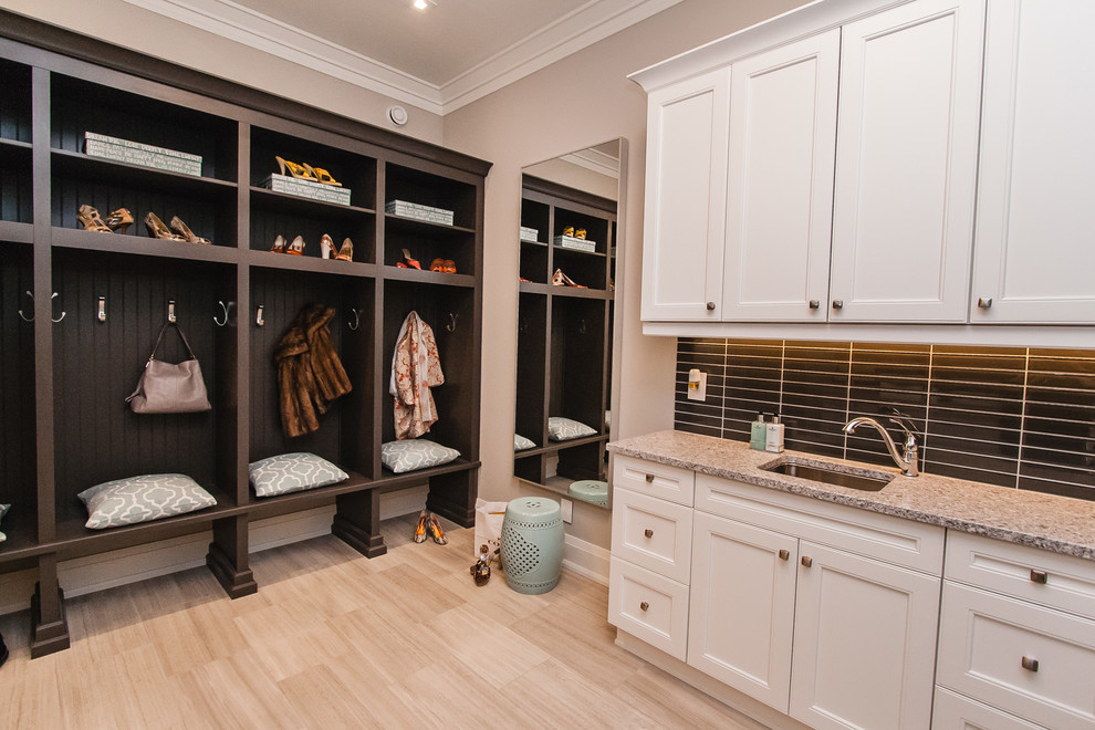 Photo of a classic utility room in Toronto with recessed-panel cabinets, white cabinets and a side by side washer and dryer.