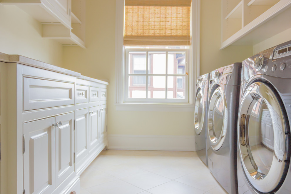 Photo of a large traditional galley separated utility room in New York with white cabinets, beige walls and a side by side washer and dryer.