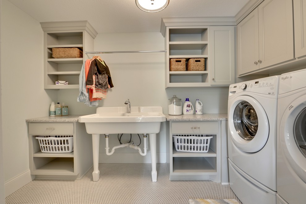 Idéer för att renovera en stor vintage l-formad tvättstuga enbart för tvätt, med en allbänk, luckor med infälld panel, grå skåp, grå väggar, klinkergolv i keramik och en tvättmaskin och torktumlare bredvid varandra