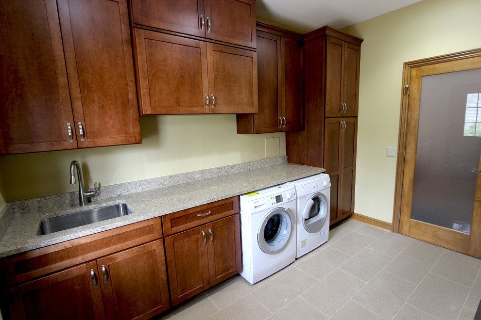 Mid-sized transitional galley porcelain tile utility room photo in Cleveland with a single-bowl sink, shaker cabinets, dark wood cabinets, quartz countertops, yellow walls and a side-by-side washer/dryer