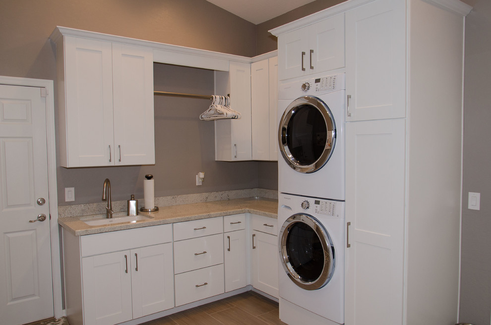 Inspiration för små klassiska l-formade tvättstugor enbart för tvätt, med en undermonterad diskho, skåp i shakerstil, vita skåp, grå väggar, en tvättpelare, bänkskiva i koppar och klinkergolv i porslin