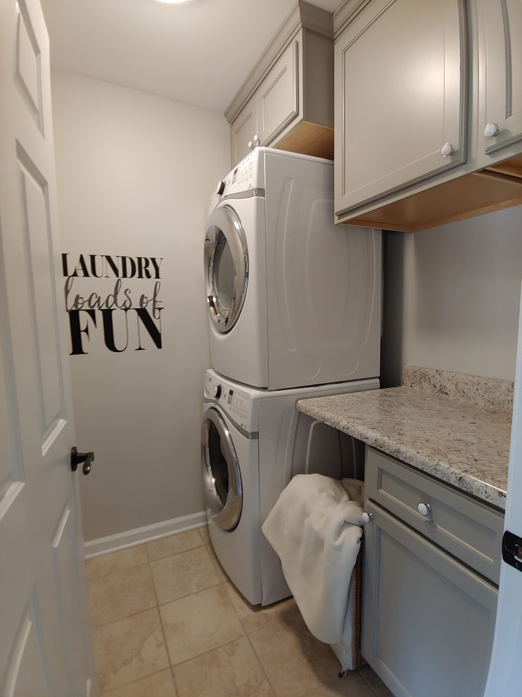 Foto på en liten funkis grå linjär tvättstuga enbart för tvätt, med skåp i shakerstil, grå skåp, laminatbänkskiva, grå väggar, klinkergolv i keramik, en tvättpelare och beiget golv
