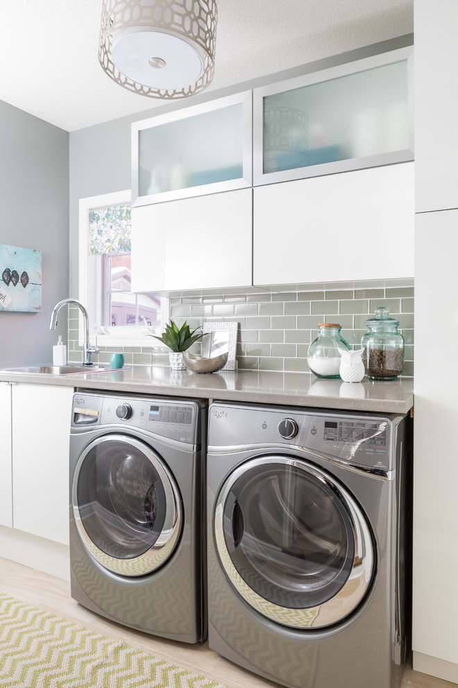 Inspiration för klassiska linjära tvättstugor enbart för tvätt, med en nedsänkt diskho, släta luckor, vita skåp, grå väggar och ljust trägolv