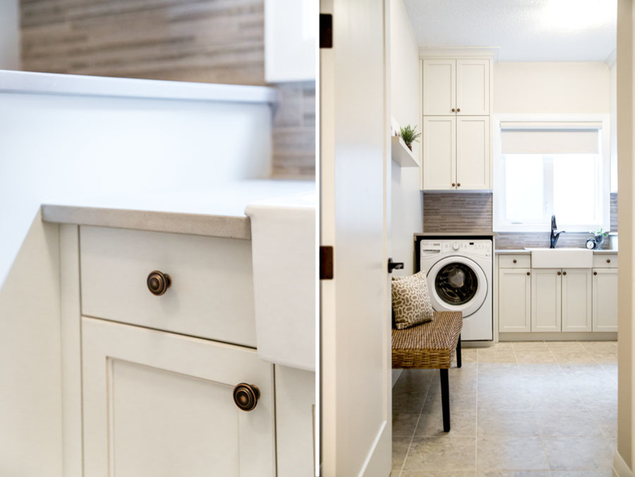 Diseño de cuarto de lavado lineal tradicional de tamaño medio con fregadero sobremueble, armarios con rebordes decorativos, puertas de armario blancas, encimera de cuarzo compacto y suelo gris