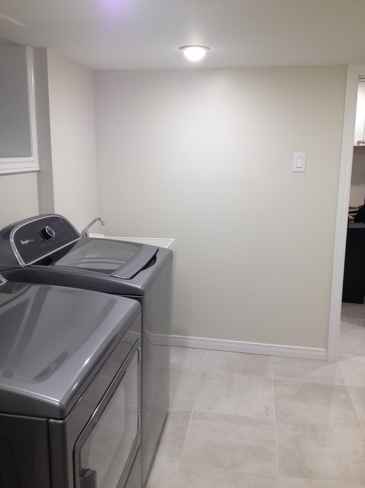 Small trendy l-shaped porcelain tile laundry room photo in Ottawa with an utility sink, gray walls and a side-by-side washer/dryer