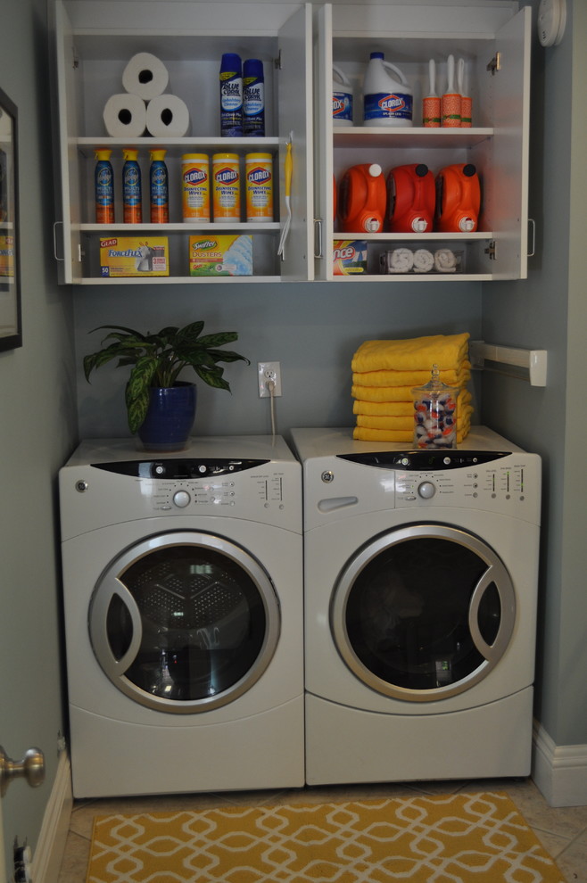 リッチモンドにある小さなトランジショナルスタイルのおしゃれな洗濯室 (フラットパネル扉のキャビネット、白いキャビネット、青い壁、セラミックタイルの床、左右配置の洗濯機・乾燥機) の写真