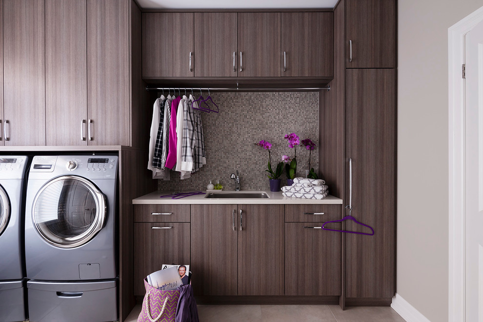 Medium sized contemporary single-wall utility room in Toronto with beige walls and a side by side washer and dryer.