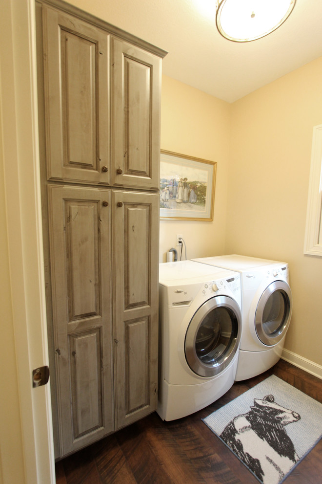 Foto di una piccola sala lavanderia classica con ante con bugna sagomata e ante in legno scuro