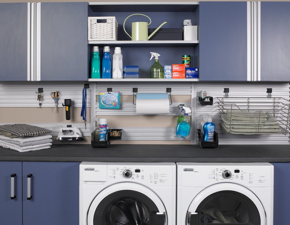 Idee per una sala lavanderia minimalista di medie dimensioni con ante lisce, ante blu, top in superficie solida, pareti multicolore e lavatrice e asciugatrice affiancate