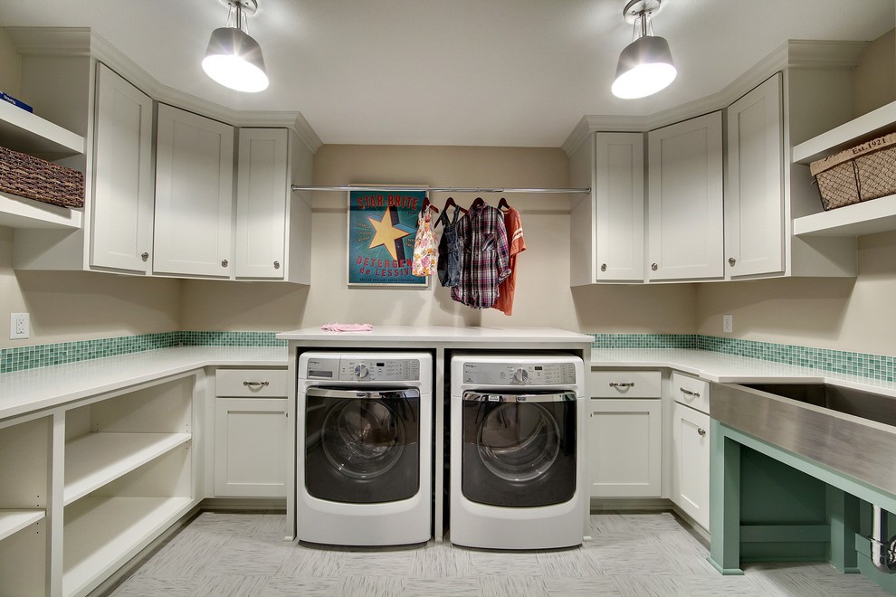 Bild på en stor vintage u-formad tvättstuga enbart för tvätt, med en rustik diskho, skåp i shakerstil, vita skåp, beige väggar, linoleumgolv och en tvättmaskin och torktumlare bredvid varandra