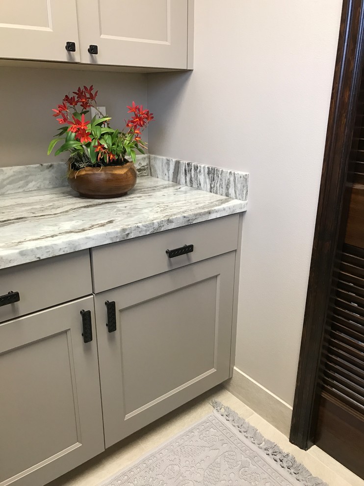 Example of a mid-sized island style u-shaped ceramic tile and beige floor dedicated laundry room design in Hawaii with an undermount sink, recessed-panel cabinets, gray cabinets, granite countertops, gray walls, a side-by-side washer/dryer and gray countertops