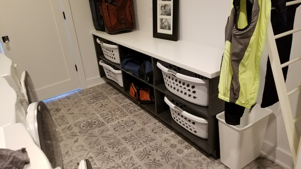Immagine di una piccola sala lavanderia design con nessun'anta, ante grigie, lavatrice e asciugatrice affiancate e top bianco