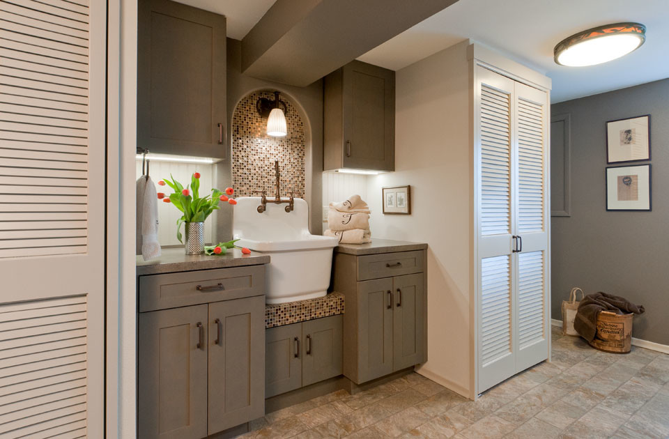 Small arts and crafts galley vinyl floor utility room photo in Seattle with a farmhouse sink, shaker cabinets, gray cabinets, gray walls and a stacked washer/dryer