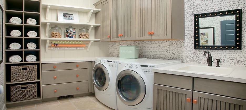 Foto på en tvättstuga, med en tvättmaskin och torktumlare bredvid varandra