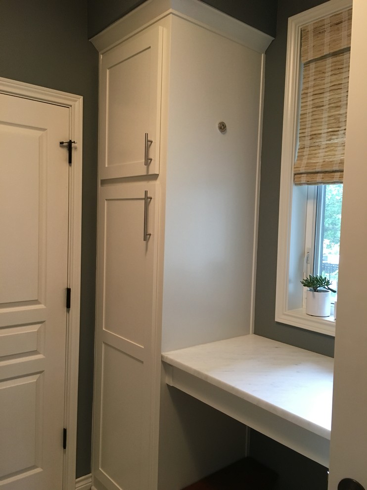 Klassisk inredning av en liten vita vitt tvättstuga, med en enkel diskho, skåp i shakerstil, vita skåp, marmorbänkskiva, grå väggar, vinylgolv, en tvättmaskin och torktumlare bredvid varandra och grått golv