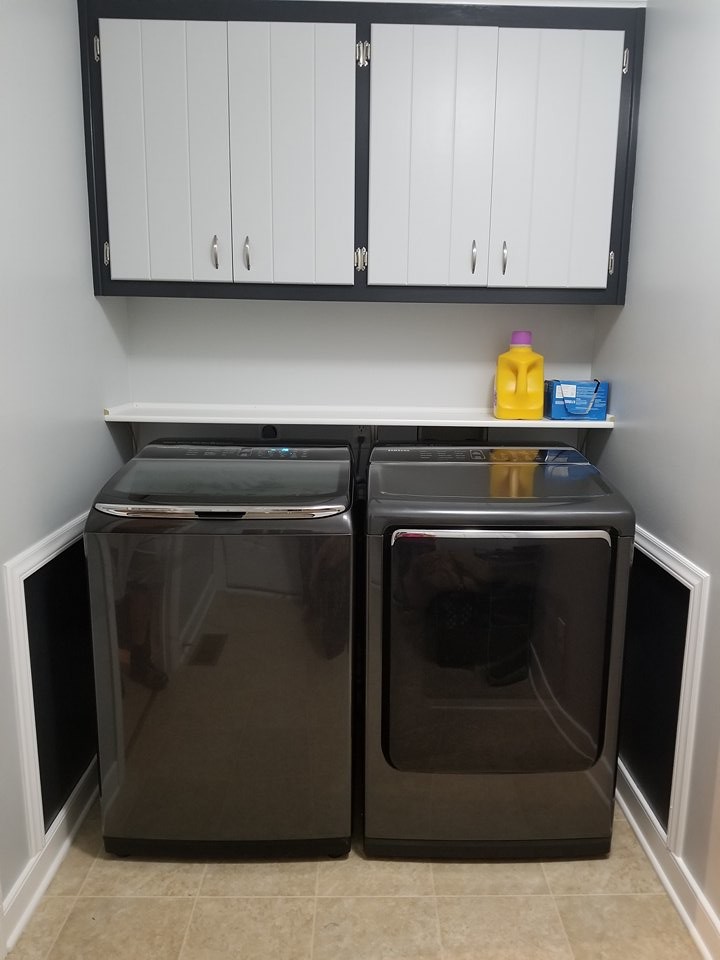 Immagine di una lavanderia minimalista con pareti grigie, pavimento in laminato, lavatrice e asciugatrice affiancate e pavimento beige