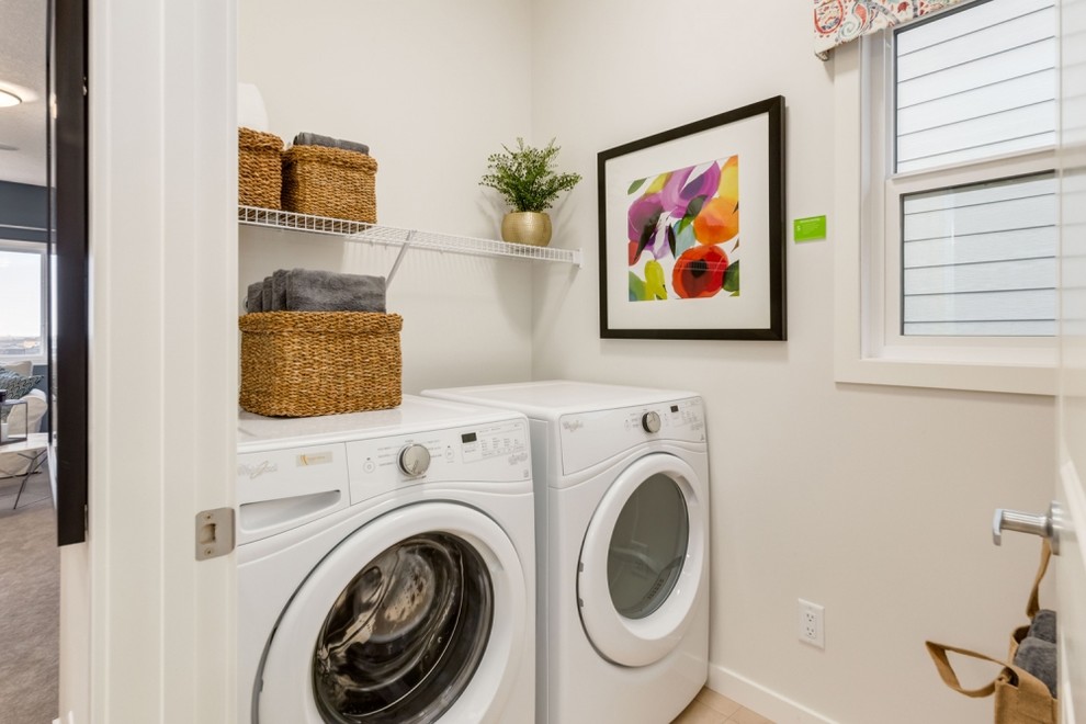 Idéer för en mellanstor modern tvättstuga enbart för tvätt, med vita väggar, laminatgolv, en tvättmaskin och torktumlare bredvid varandra och beiget golv