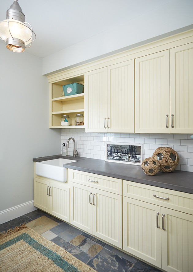 Inspiration for a medium sized beach style galley separated utility room in Grand Rapids with a belfast sink, shaker cabinets, concrete worktops, slate flooring, a side by side washer and dryer, beige cabinets and grey walls.