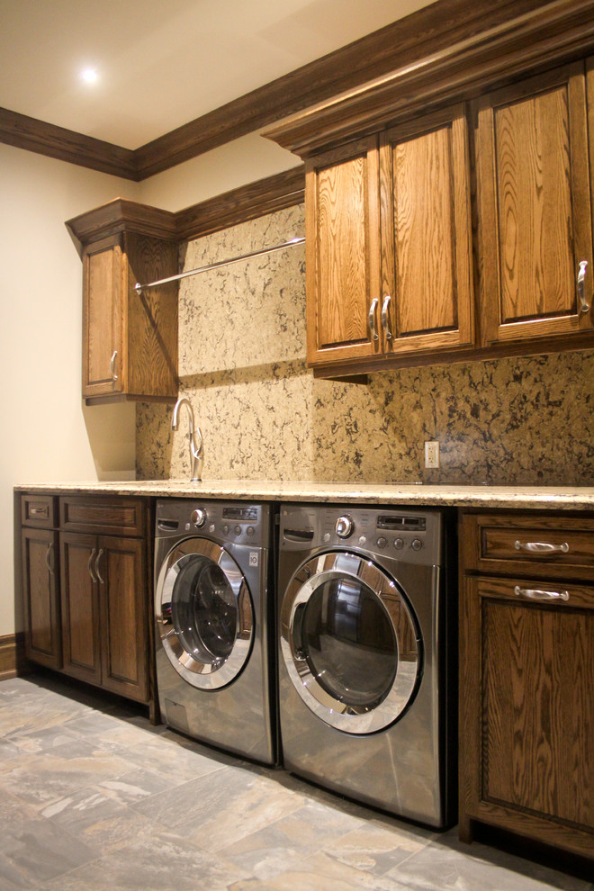 Large mountain style single-wall utility room photo in Toronto with an undermount sink, raised-panel cabinets, medium tone wood cabinets, granite countertops, beige walls and a side-by-side washer/dryer