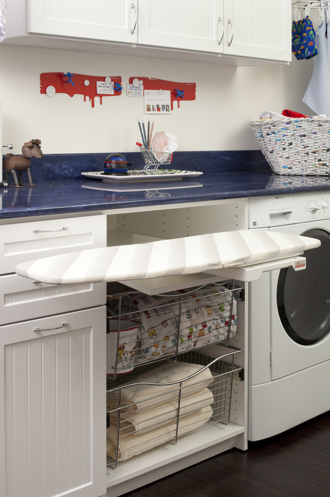 Foto de lavadero lineal clásico con armarios estilo shaker, puertas de armario blancas, encimera de acrílico, lavadora y secadora juntas y paredes blancas