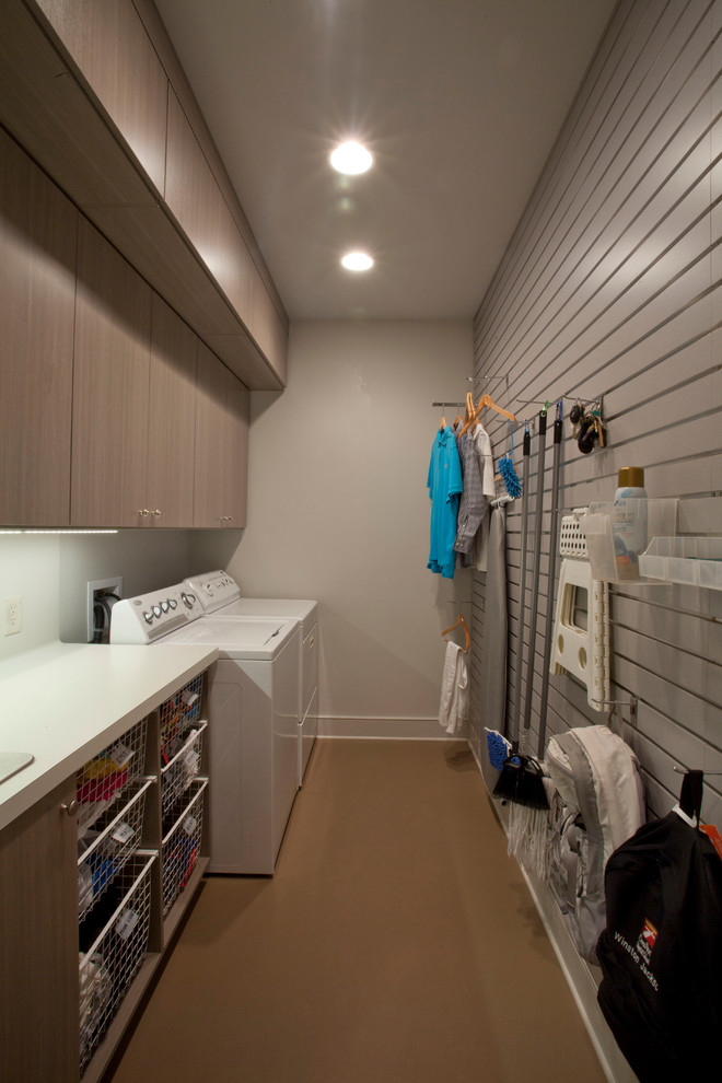 Foto di una lavanderia moderna con lavello da incasso, top in laminato, pareti grigie, pavimento in sughero e lavatrice e asciugatrice affiancate