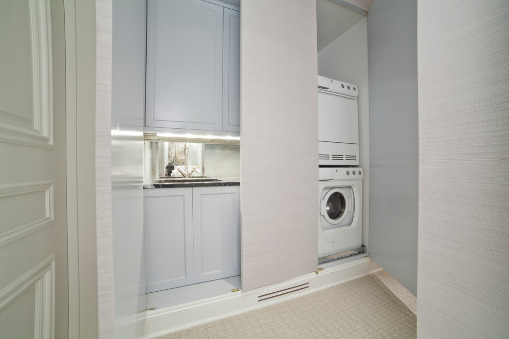 Foto på en liten funkis linjär liten tvättstuga, med en enkel diskho, luckor med infälld panel, vita skåp, granitbänkskiva, grå väggar, klinkergolv i keramik och en tvättpelare
