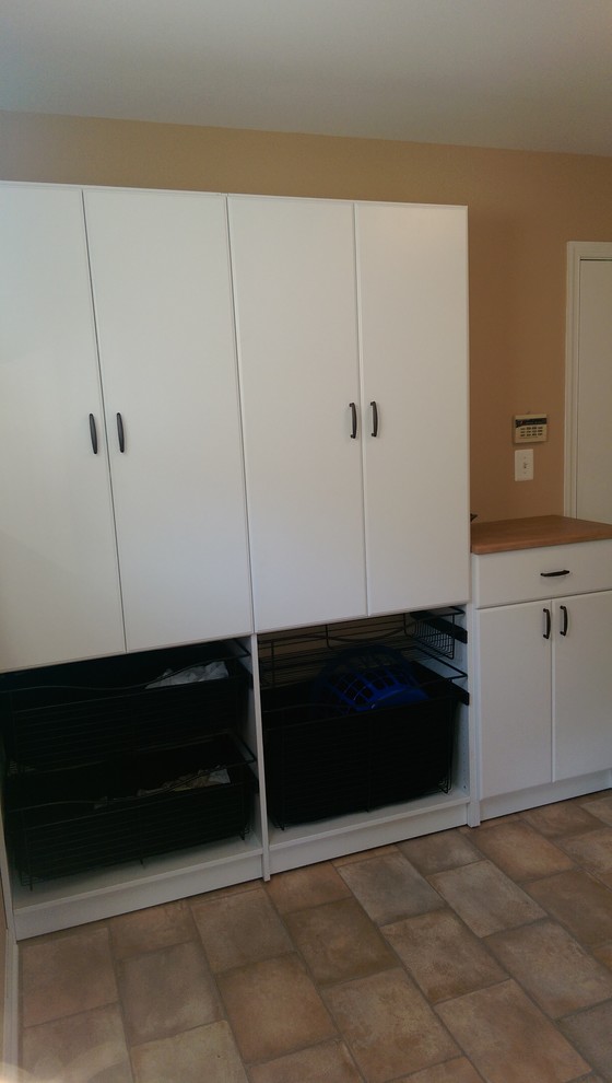 Example of a mid-sized classic single-wall utility room design in Philadelphia with flat-panel cabinets, white cabinets and laminate countertops