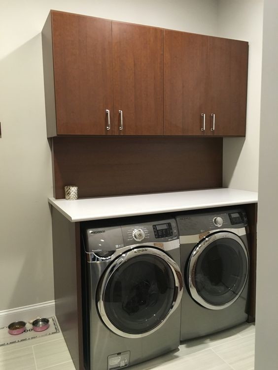 Inspiration for a mid-sized timeless ceramic tile utility room remodel in St Louis with flat-panel cabinets, dark wood cabinets, laminate countertops and a side-by-side washer/dryer