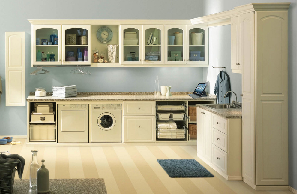 Immagine di una grande lavanderia multiuso tradizionale con lavello da incasso, ante con bugna sagomata, ante beige, top in granito, pareti blu e lavatrice e asciugatrice affiancate