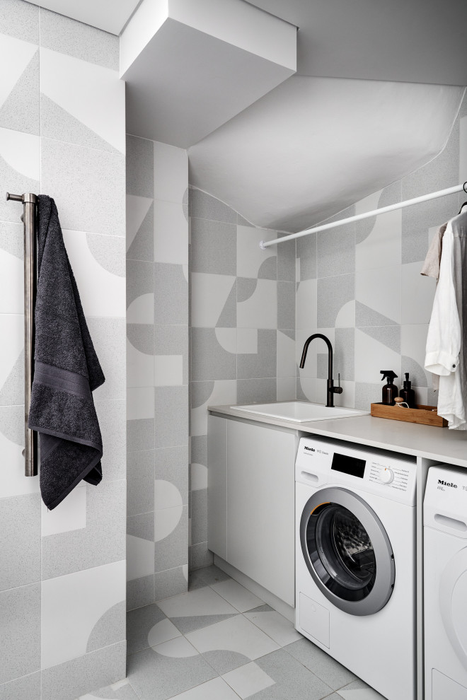Idee per una piccola lavanderia multiuso scandinava con lavello da incasso, top in quarzo composito, pareti grigie, pavimento in gres porcellanato, lavatrice e asciugatrice affiancate, pavimento grigio e top bianco