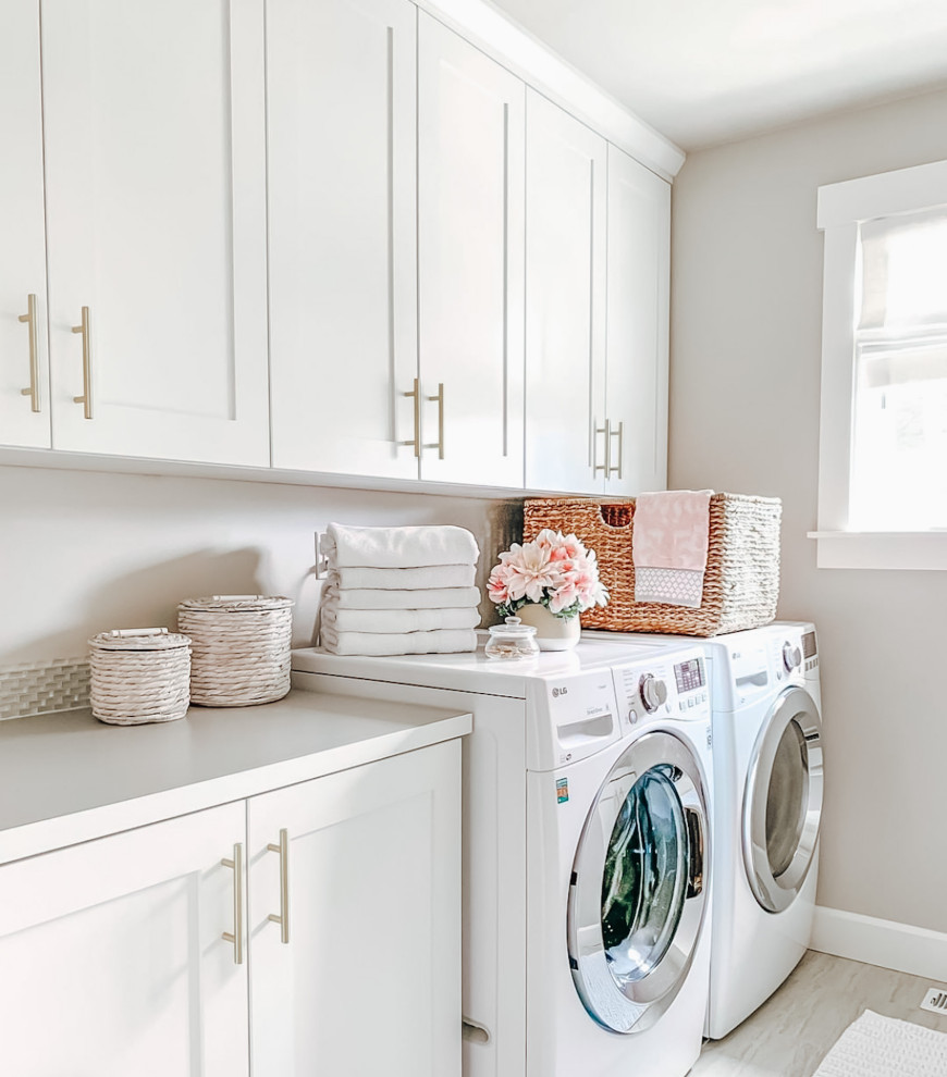 Exempel på en mellanstor klassisk vita parallell vitt tvättstuga enbart för tvätt, med vita skåp, en tvättmaskin och torktumlare bredvid varandra, grått golv, bänkskiva i kvartsit, stänkskydd i keramik, grått stänkskydd, vita väggar och ljust trägolv
