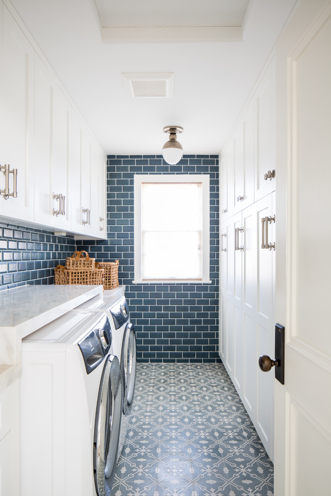 Foto di una sala lavanderia country con ante con riquadro incassato, ante bianche, pareti blu, lavatrice e asciugatrice affiancate, pavimento blu e top bianco