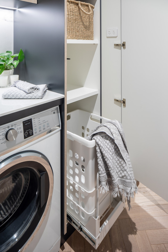 Esempio di una piccola lavanderia multiuso moderna con lavello sottopiano e paraspruzzi in gres porcellanato