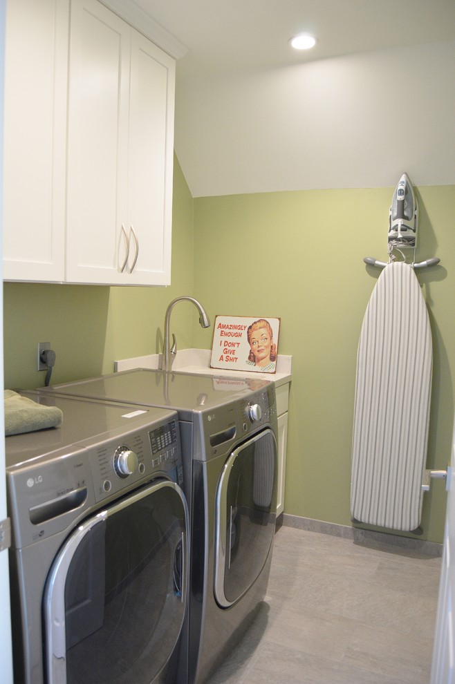 Idéer för mellanstora vintage linjära tvättstugor enbart för tvätt, med en undermonterad diskho, luckor med infälld panel, vita skåp, bänkskiva i kvartsit, gröna väggar, klinkergolv i porslin och en tvättmaskin och torktumlare bredvid varandra